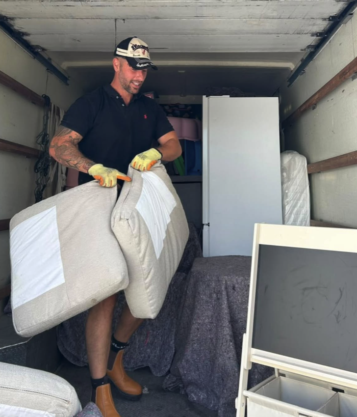 A Devon Heritage Removals team member loading padded furniture into the van